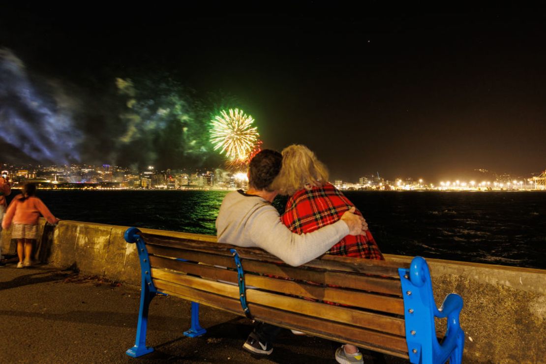 Gente reunida alrededor de la laguna Whairepo para escuchar música y contemplar los fuegos artificiales del Año Nuevo en Wellington, Nueva Zelandia.