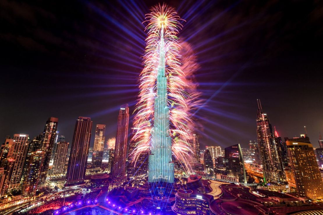 Los fuegos artificiales iluminan el cielo junto al emblemático rascacielos Burj Khalifa, el edificio más alto del mundo, en Dubai a la medianoche de la víspera de Año Nuevo el 1 de enero de 2024.