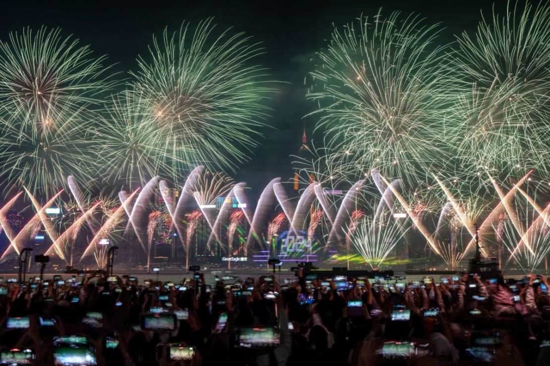 La gente observa la explosión de fuegos artificiales sobre el puerto de Victoria para marcar la llegada del año 2024 en Hong Kong, China, el 1 de enero de 2024.