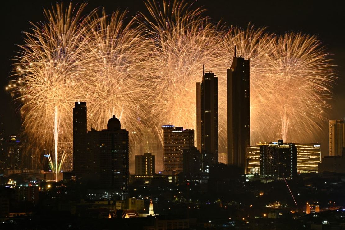 Los fuegos artificiales explotan sobre el horizonte de la ciudad a lo largo del río Chao Phraya durante las celebraciones de Año Nuevo en Bangkok el 1 de enero de 2024.