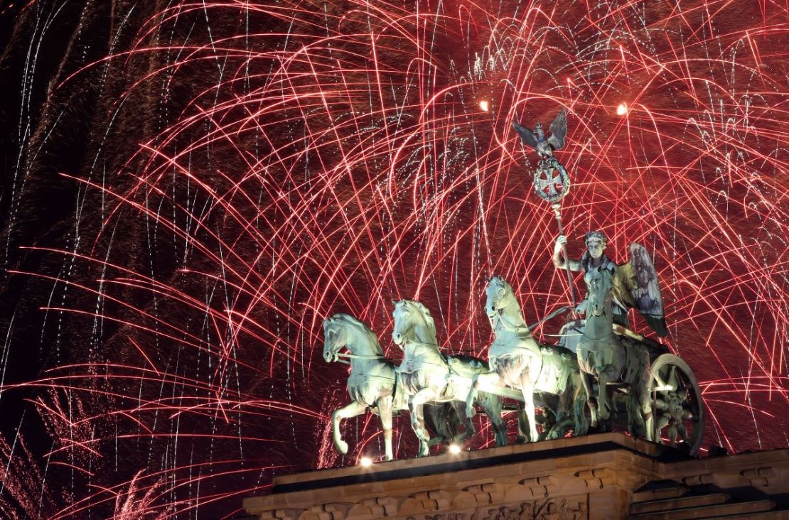 Los fuegos artificiales explotan sobre la Puerta de Brandenburgo a la medianoche del día de Año Nuevo, el 1 de enero de 2024 en Berlín, Alemania.