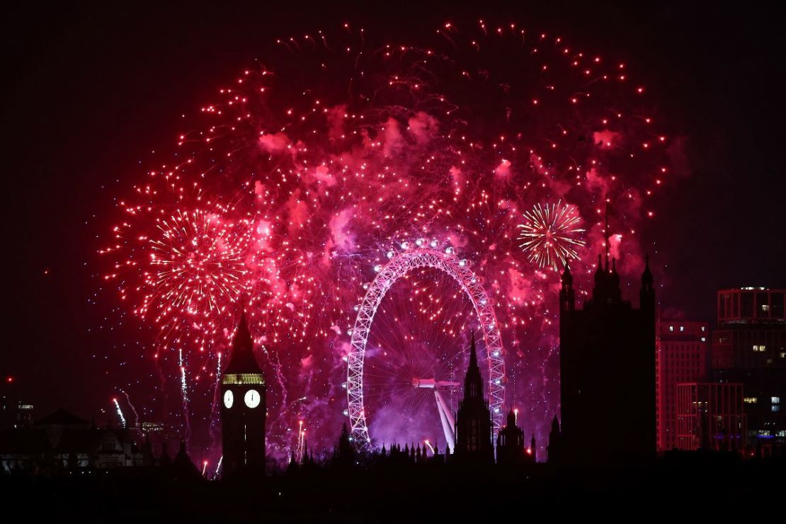 Los fuegos artificiales explotan alrededor del London Eye y la Torre Elizabeth, comúnmente conocida por el nombre de la campana del reloj, "Big Ben", en el Palacio de Westminster, sede de las Casas del Parlamento, en el centro de Londres, poco después de la medianoche del 1 de enero. 2024.