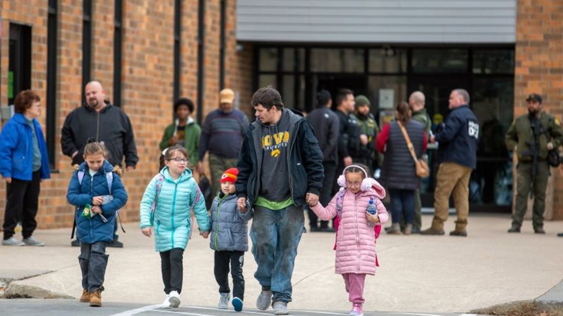 Un hombre y sus niños abandonan el McCreary Community Building después de reunirse el jueves tras un tiroteo en la escuela secundaria Perry High School cerca de Des Moines, Iowa.