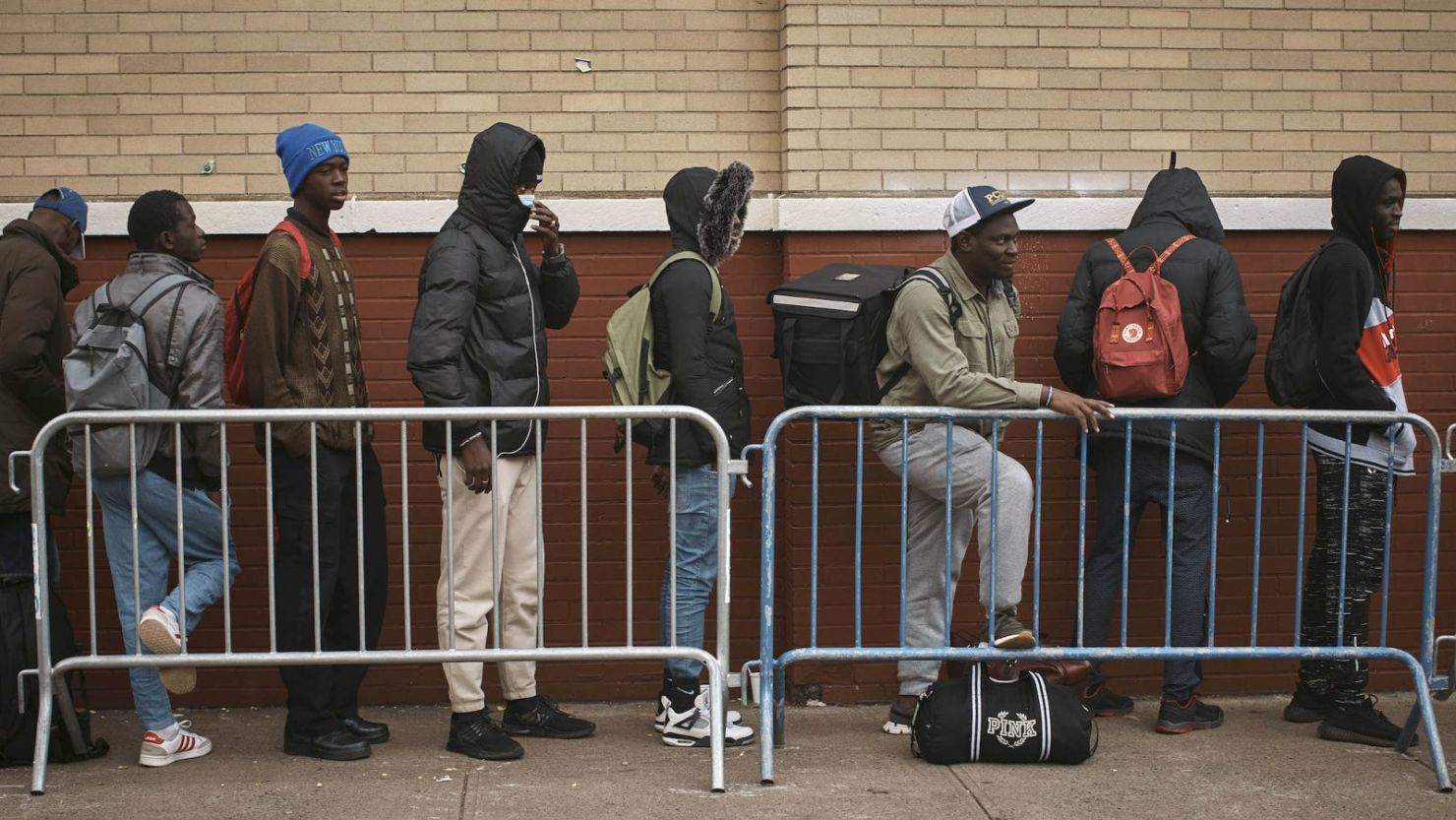 Migrantes hacen fila en el frío mientras buscan refugio afuera de un Centro de Asistencia a Migrantes en la Escuela Primaria St. Brigid el martes 5 de diciembre de 2023 en Nueva York.