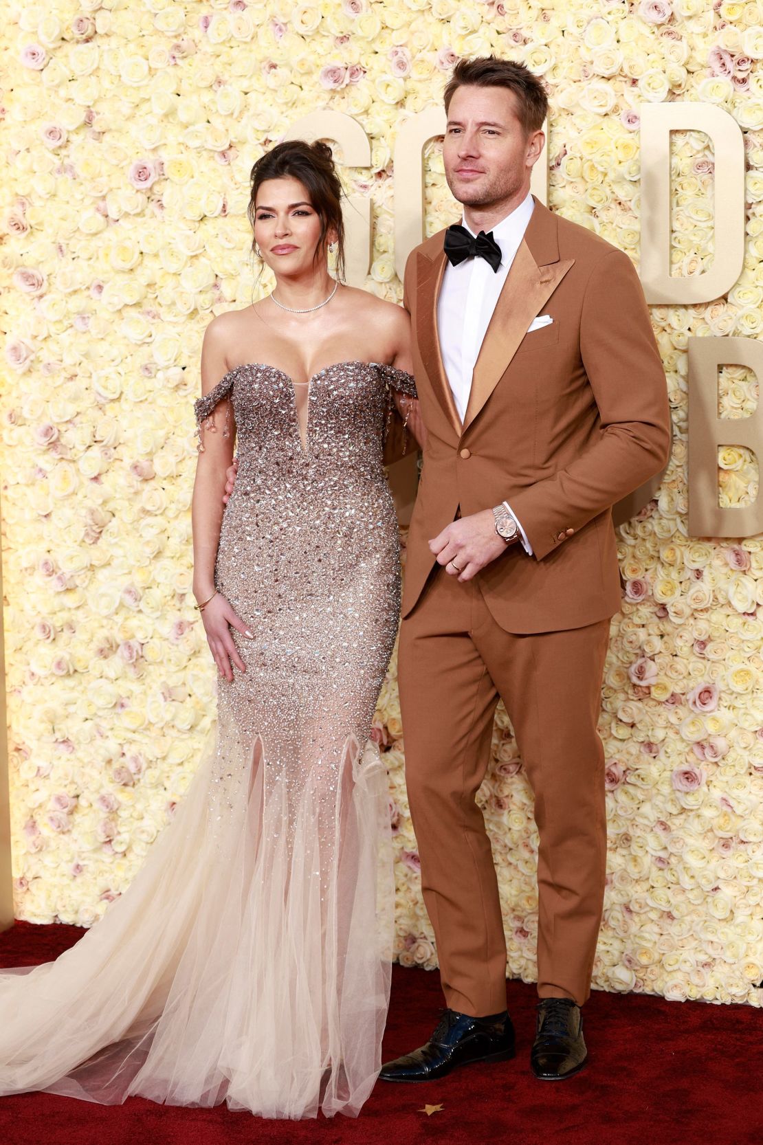 La actriz Sofía Pernas se vistió toda de brillo y tul en un vestido de sirena con los hombros descubiertos de Pamella Roland. Su esposo, la estrella de "This is Us" Justin Hartley, llevaba un esmoquin ocre de Nana Sartoria combinado con pajarita oscura, zapatos Oxford de charol negro de Christian Louboutin y un reloj Rolex.