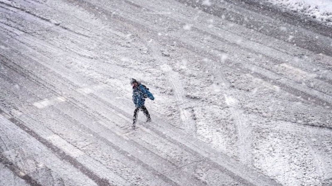 Un peatón navega por una calle cubierta de nieve en Iowa City, Iowa, el 9 de enero de 2024.