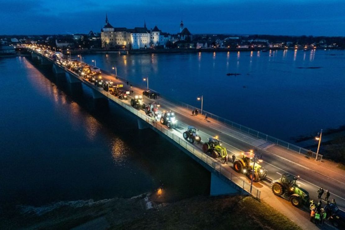 Tractores pasan por el castillo de Hartenfels y cruzan el río Elba en Torgau, al este de Alemania.