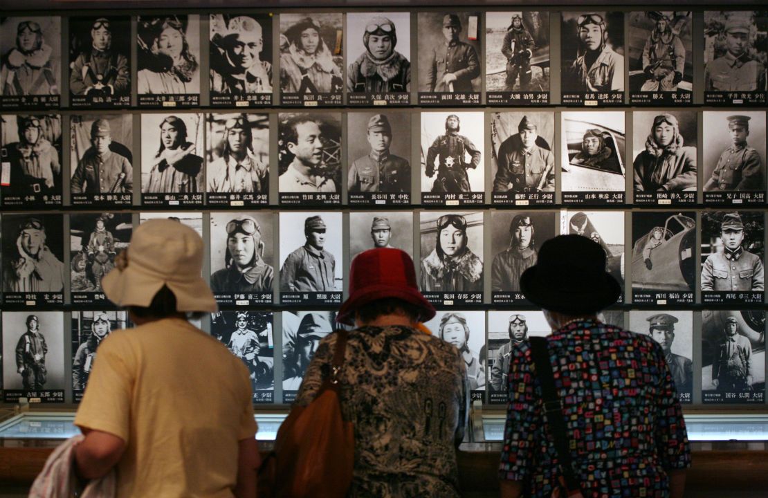 Tres mujeres miran fotografías de pilotos kamikazes japoneses, que dieron su vida en ataques suicidas contra las fuerzas estadounidenses en la Segunda Guerra Mundial, colgadas en una pared del Museo de la Paz de Chiran.