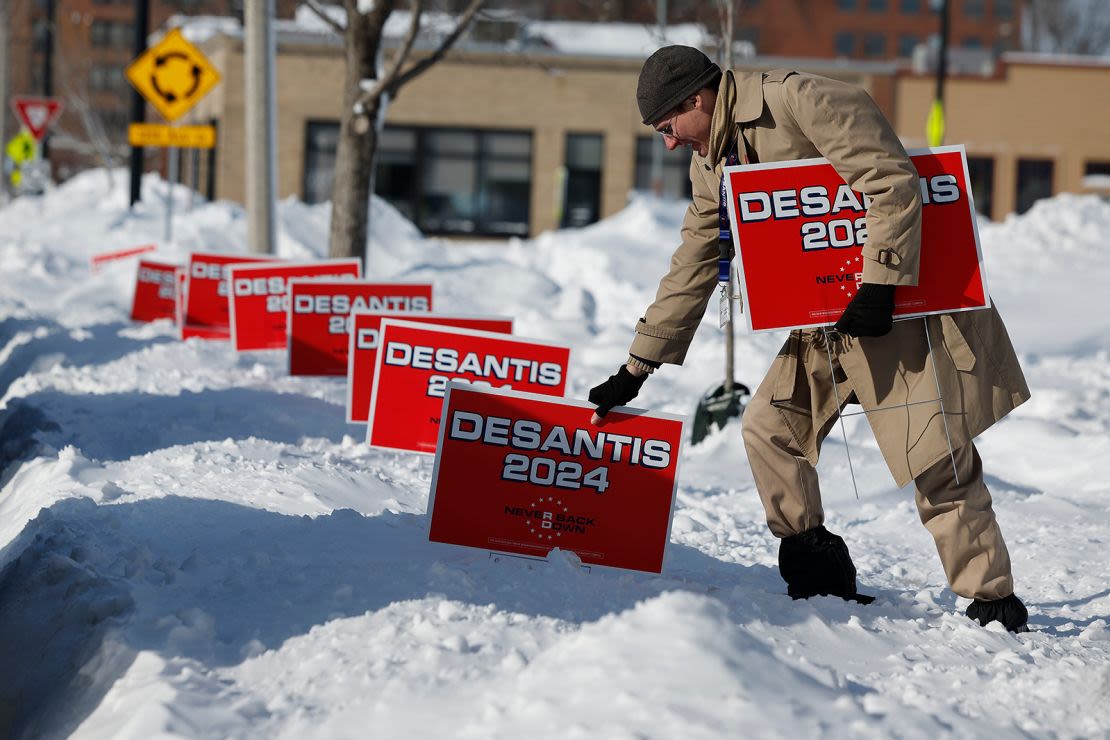 Un voluntario coloca carteles a favor de DeSantis fuera del Chrome Horse Saloon un día antes de los caucus de Iowa 2024 en Cedar Rapids.