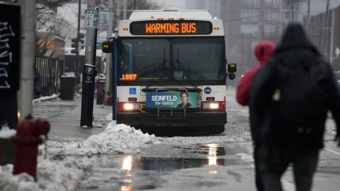 La nieve cae el viernes mientras las migrantes se mantienen calientes en los autobuses urbanos de Chicago. Crédito: Erin Hooley/AP