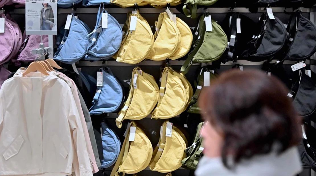 Una mujer pasa junto a un estante del mini bolso de hombro redondo viral en una tienda Uniqlo en Tokio, Japón, el 16 de enero de 2024.Richard A. Brooks/AFP/Getty Images