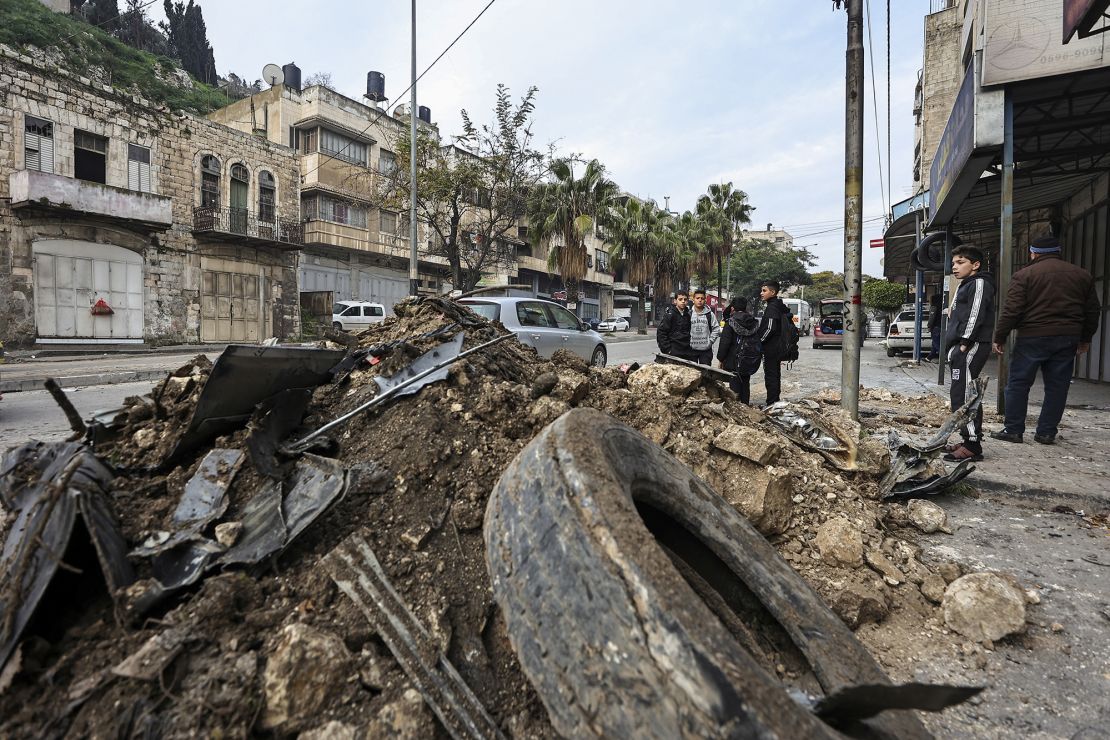 Un grupo de niños mira un automóvil destruido por un ataque aéreo israelí cerca del campo de refugiados Balata en la Ribera Occidental, este 17 de enero.