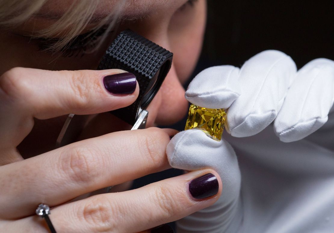 Un empleado inspecciona un diamante de corte Asscher de color amarillo intenso en una exposición de la colección de grandes diamantes de color de Alrosa, el 13 de febrero de 2019 en Moscú. Con un peso de 20,69 quilates, es el diamante amarillo más grande extraído en Rusia en 2017.