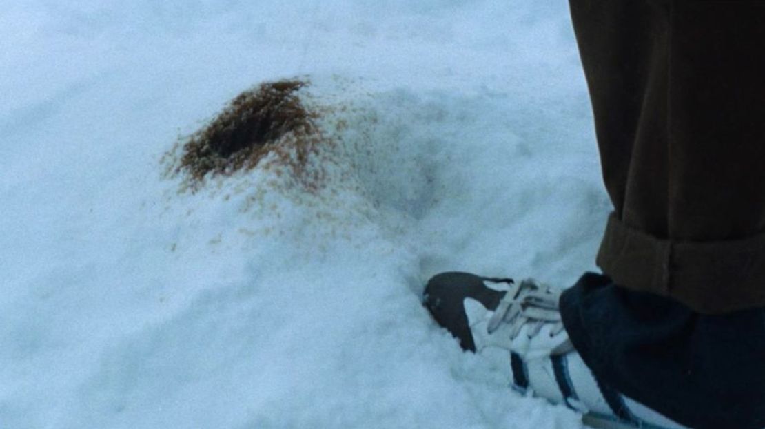 Captura de una escena de la película "La sociedad de la nieve", en la que se ve que los sobrevivientes de la tragedia de los Andes orinaban de un color casi negro.