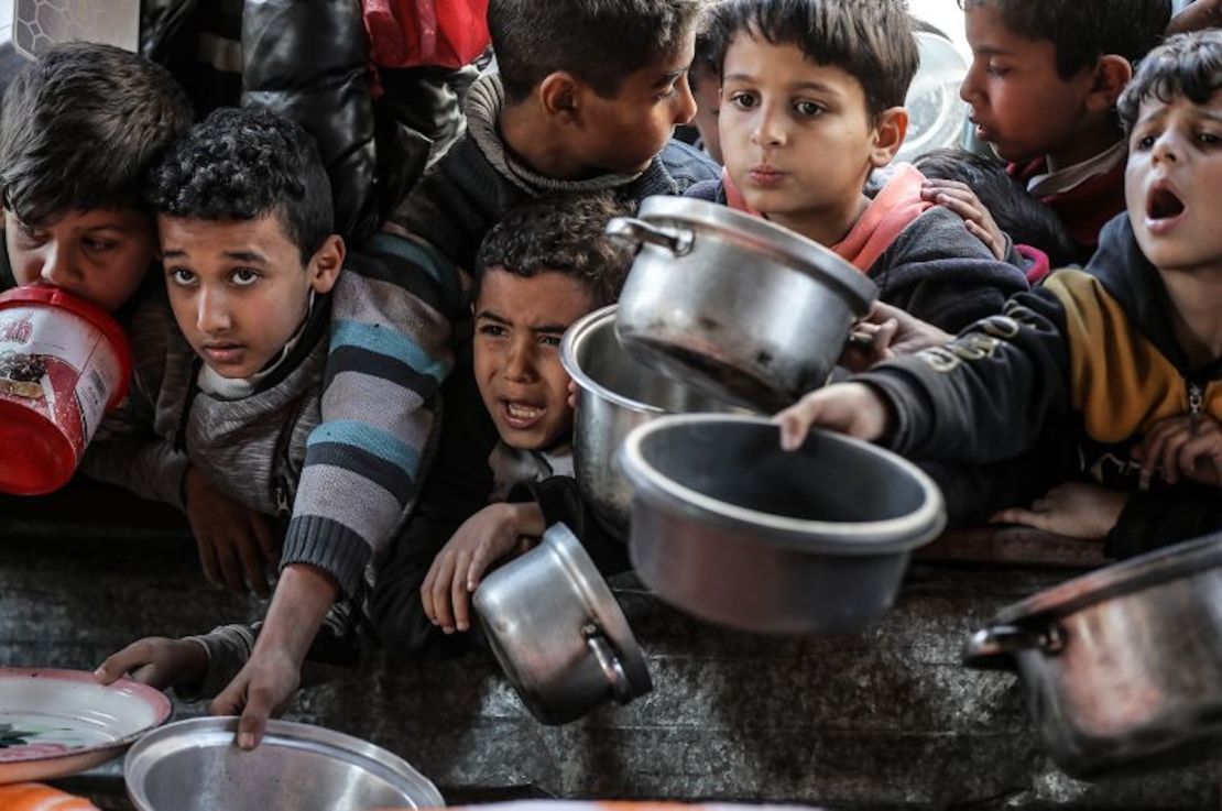 Niños esperan que las organizaciones de ayuda les entreguen alimentos en Rafah.