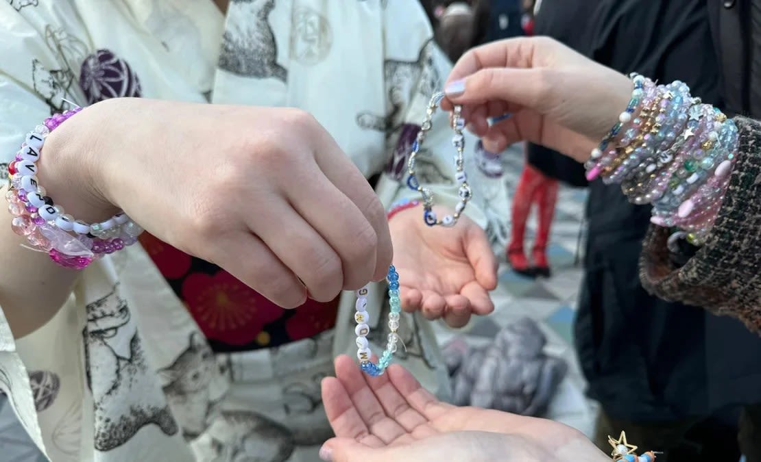 Los fanáticos intercambian pulseras de la amistad personalizadas antes del concierto de Taylor Swift en Tokio, Japón, el 7 de febrero de 2024.