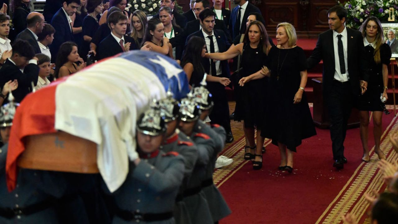 The wife of late former President Sebastian Piñera, Cecilia Morel, accompanied by her family, walks while carabineers transport Piñera's coffin during his state funeral at the National Congress Palace in Santiago on February 9, 2024. Former presidents and politicians of Chile, from left to right, as well as family and followers say goodbye this Friday to former President Sebastian Piñera, who died on Tuesday while piloting his helicopter in the south of the country. (Photo by Pablo Vera / AFP)