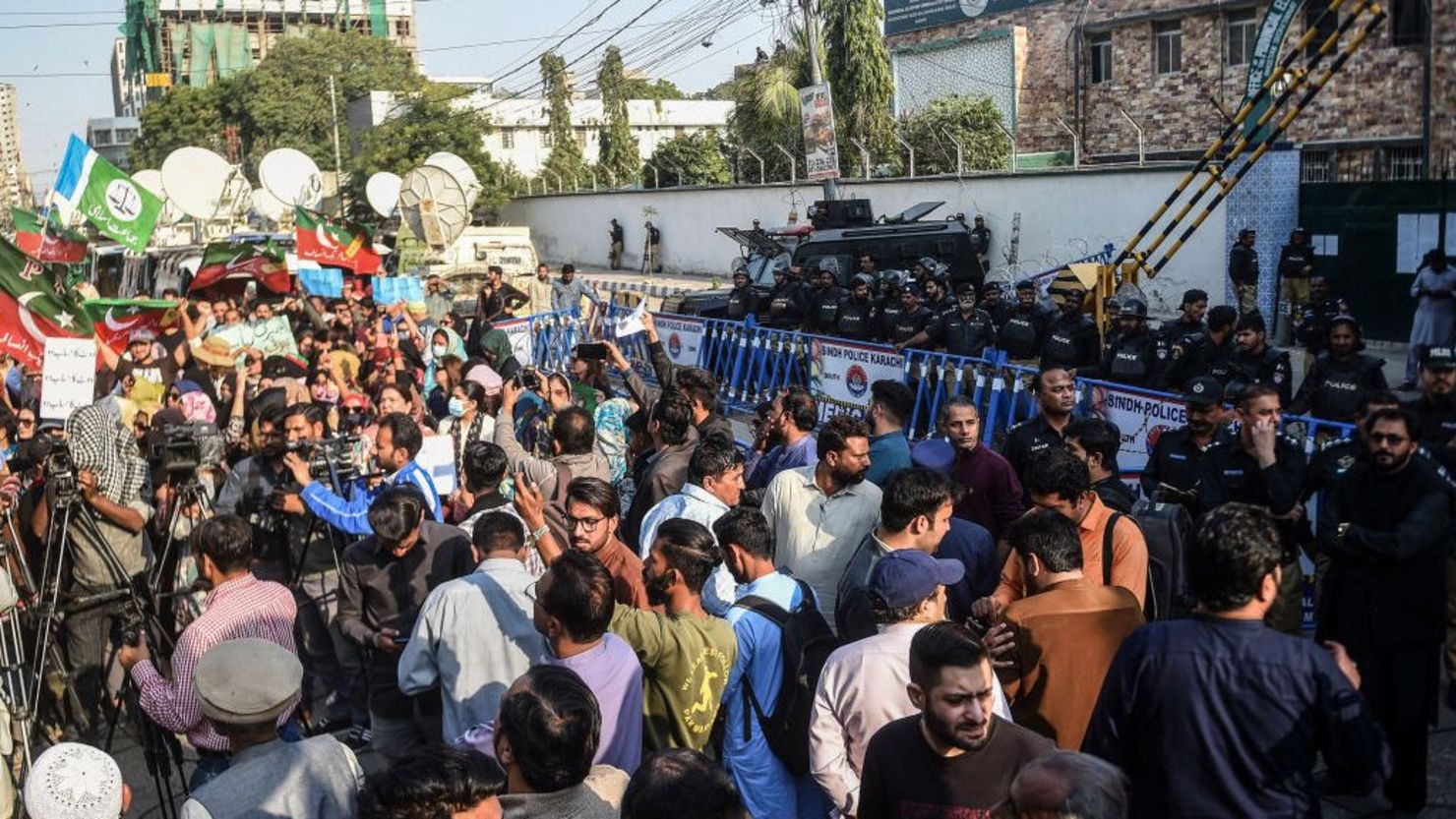 La policía hace guardia mientras los partidarios del partido Pakistan Tehreek-e-Insaf (PTI) protestan frente a una oficina de la comisión electoral en Karachi el 10 de febrero de 2024