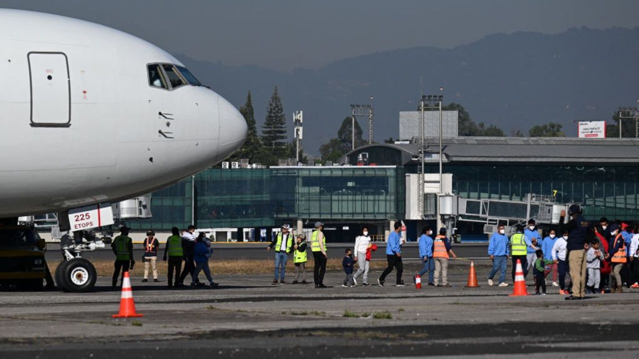 Guatemalan migrants deported from the United States walk on the tarmac after landing at the Air Force Base in Guatemala City in the first flight of deportees of the year on January 3, 2024. The US deported 55.000 Guatemalans between January and December 2023, a record that exceeds that of 2019, of 54,500, according to records of the General Directorate of Migration of Guatemala. (Photo by Johan ORDONEZ / AFP)