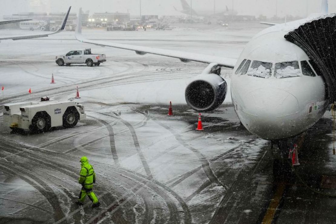 Un hombre camina cerca de un avión que espera mientras cae nieve en el Aeropuerto Internacional John F. Kennedy de Nueva York. Frank Franklin II/AP