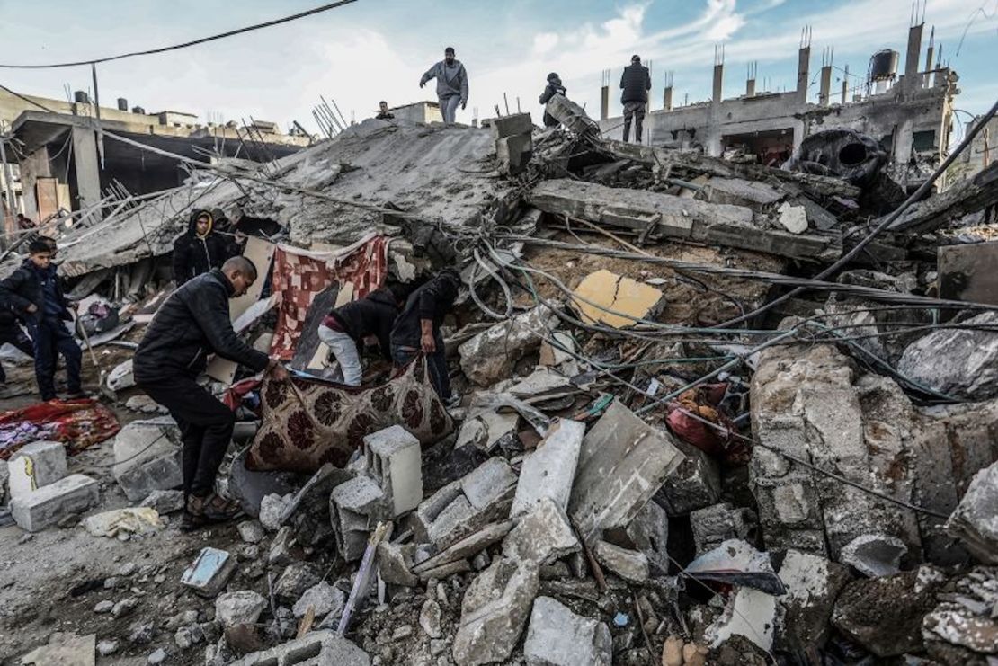 Palestinos inspeccionan edificios dañados después de los ataques aéreos israelíes en Rafah, en el sur de la Franja de Gaza, el 12 de febrero de 2024.