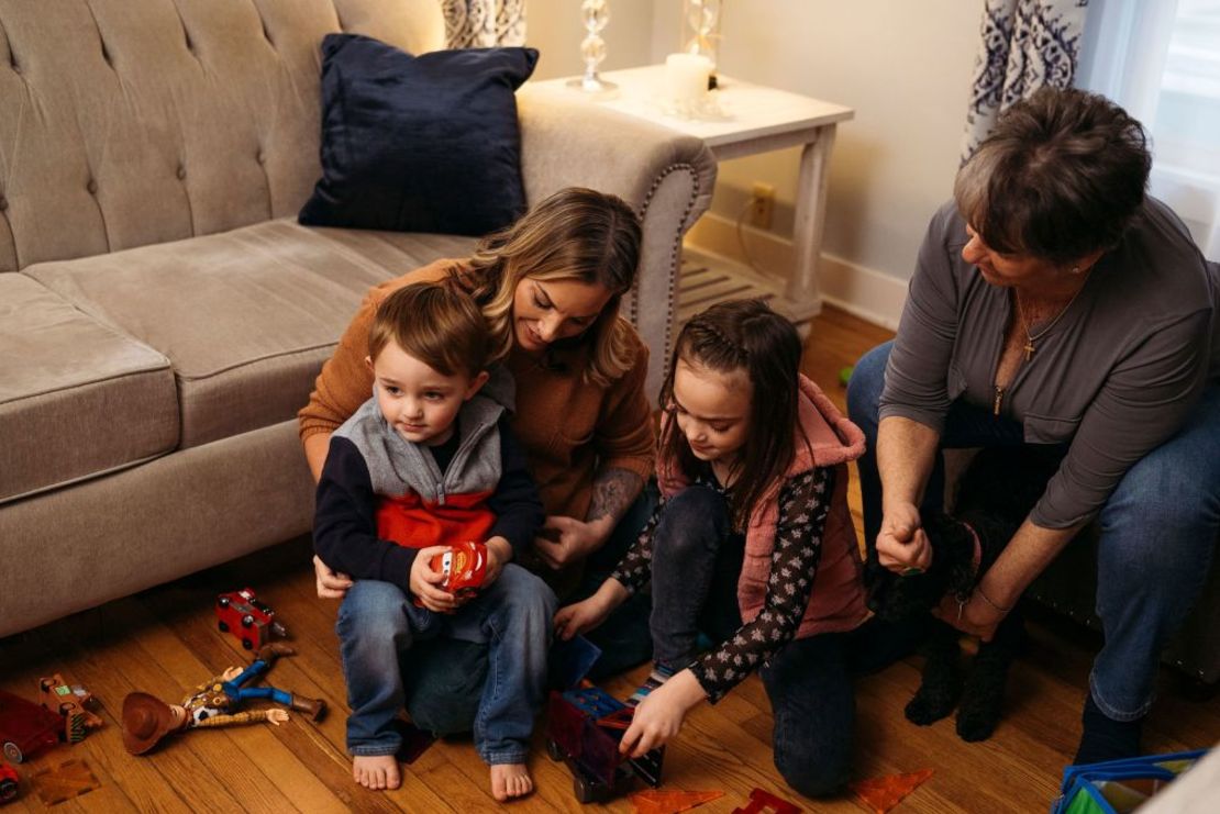 Victoria Hill y sus dos hijos juegan con juguetes en la sala de estar de la casa de su madre en Wethersfield. Crédito: Laura Oliverio/CNN