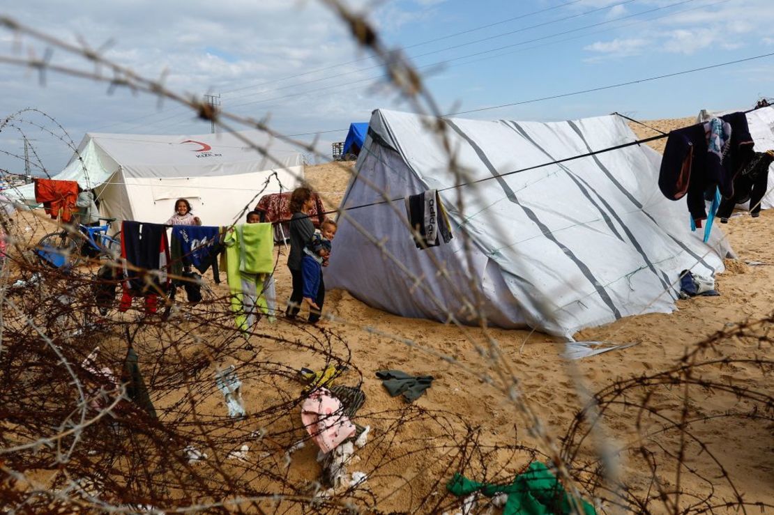 Unos niños junto a unas tiendas de campaña en las que se refugian palestinos desplazados que huyeron de sus casas debido a los ataques israelíes en Rafah, en el sur de Gaza, el 26 de enero. Crédito :Ibraheem Abu Mustafa/Reuters