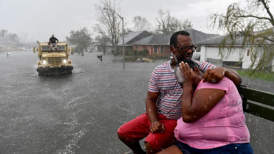 Personas empapadas por la lluvia del huracán Ida mientras evacúan fuera de un vecindario inundado en un camión de aguas altas después de que los vecindarios se inundaran en LaPlace, Louisiana, el 30 de agosto de 2021.