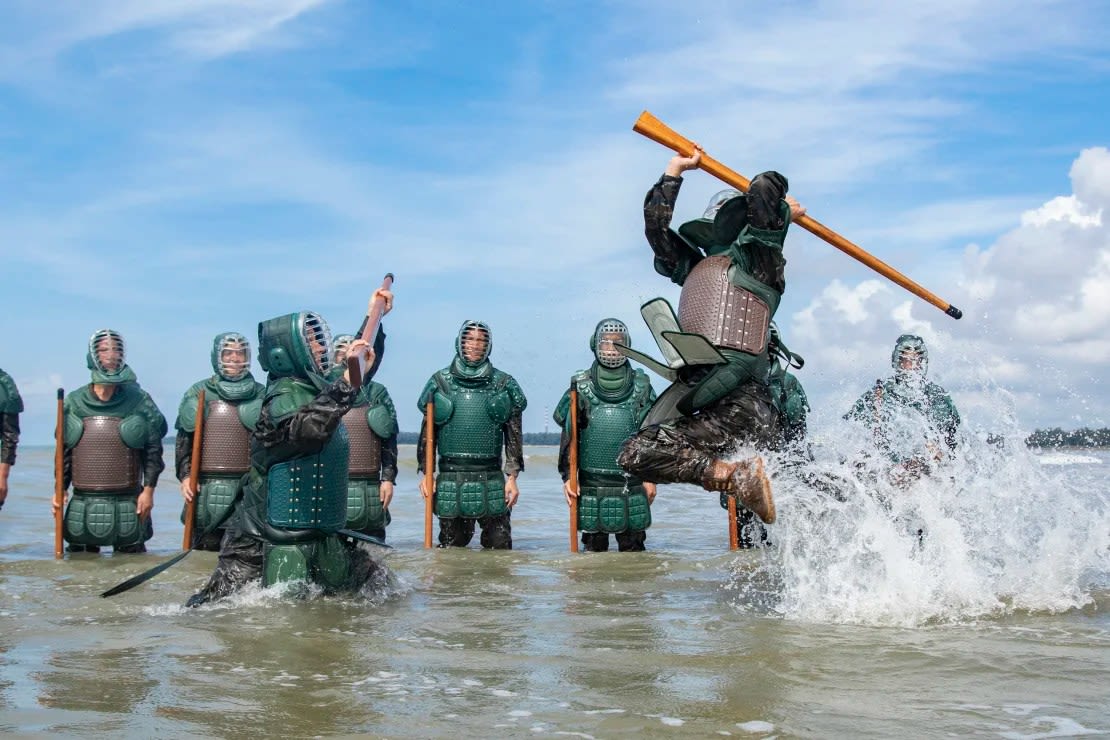 Policías armados y soldados entrenándose en agua de mar en la ciudad de Fangchenggang, en la región autónoma china de Guangxi, el 24 de julio de 2023.