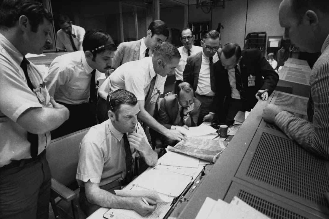 Los controladores de vuelo se reúnen alrededor del director de vuelo de la NASA, Glynn Lunney (sentado, en primer plano) en la sala de control de lo que ahora se llama el Centro Espacial Johnson en Houston durante la abortada misión lunar del Apolo 13, el 15 de abril de 1970. Space Frontiers/Archive Photos/Getty Images