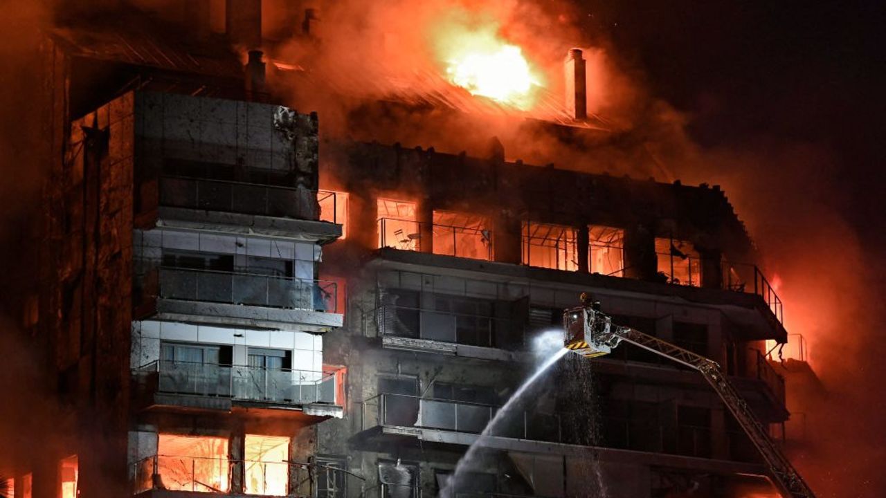 TOPSHOT - Firefighters battle a huge fire raging through a multistorey residential block in Valencia on February 22, 2024. Spanish firefighters were battling a huge fire raging through a multistorey residential block in the eastern port city of Valencia today, the emergency services said. Flames and vast clouds of black smoke engulfed the building, with 22 teams of firefighters battling high winds to tackle the blaze, the 112 emergency services said. In a post on X, formerly Twitter, the emergency services said seven people had been lightly injured: a minor, three adults and three firefighters, most of them suffering from smoke inhalation. (Photo by Jose Jordan / AFP)