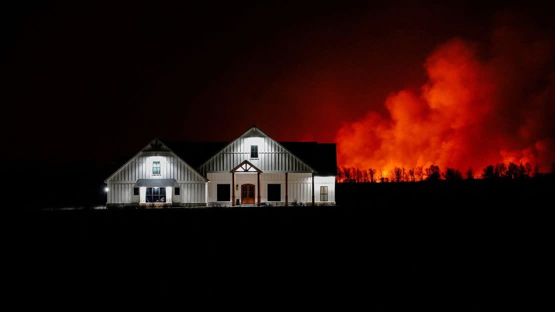 Un incendio forestal arde detrás de una casa en las afueras de Shattuck, Oklahoma, el 27 de febrero de 2024.