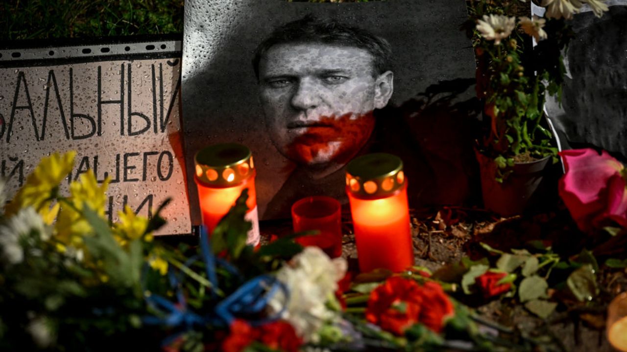 This photograph taken in Sofia on March 1, 2024, on the day of his funeral in Moscow, shows candles, flowers left as a tribute to Russian opposition leader Alexei Navalny. Navalny, whose death in an Arctic prison was announced on February 16, was Russian President Vladimir Putin's most prolific critic for over a decade, blasting what he called rampant corruption and refusing to back down even after being poisoned. (Photo by Nikolay DOYCHINOV / AFP)