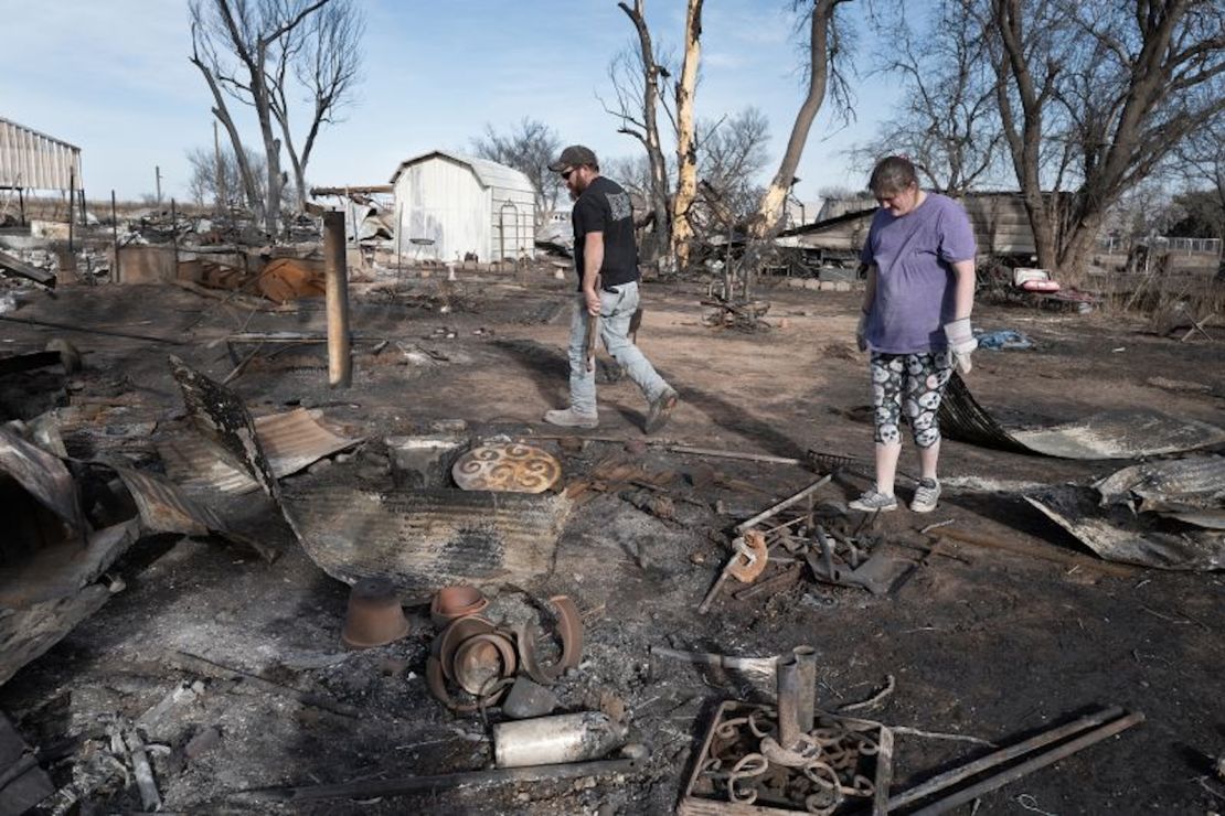 Tia Champion y su esposo Tim ayudan a una amiga a buscar los restos de su casa cerca de Stinnett, Texas, después de que fuera destruida por el incendio de Smokehouse Creek.