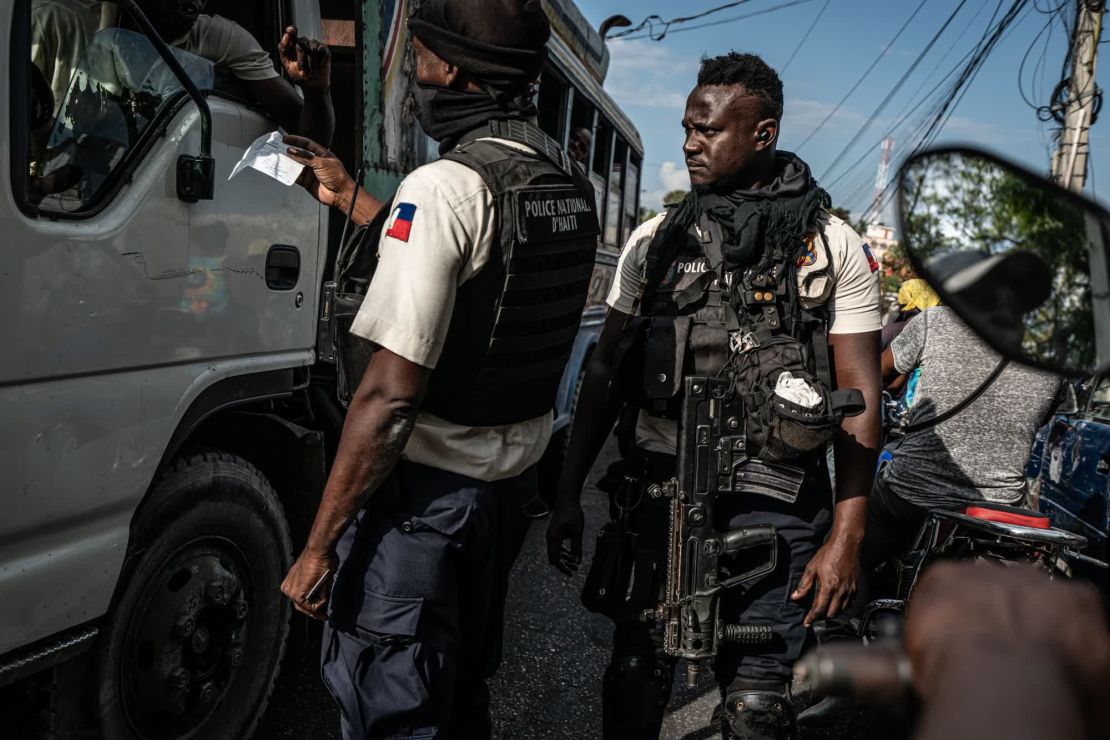 La policía haitiana inspecciona documentos en un puesto de control en una calle que va del centro de la ciudad al puerto. Es uno de los pocos lugares controlados por la policía, afirmó el fotoperiodista Giles Clarke.