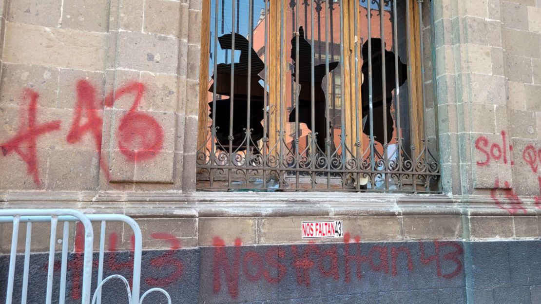 Vista de los cristales rotos de una ventana rota por manifestantes en el palacio presidencial de la Ciudad de México el 6 de marzo de 2024, durante una protesta por la desaparición de los 43 estudiantes de Ayotzinapa en 2014. (Foto: Ivan Castaneira/AFP vía Getty Images).