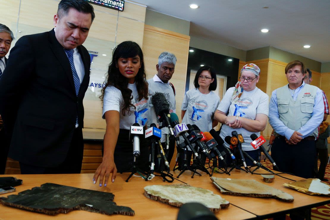 Grace Subathirai Nathan (2ª, desde la izquierda), hija de la pasajera Anne Daisy, muestra al ministro de Transporte de Malasia, Anthony Loke (extremo izquierdo), piezas de los restos encontrados en Madagascar, que se cree que son del vuelo MH370, en Putrajaya el 30 de noviembre de 2018.