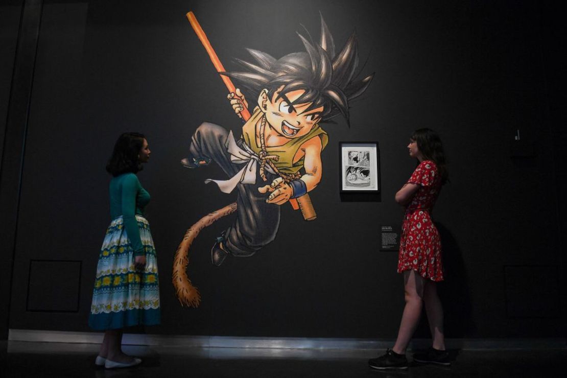 Los empleados del museo posan junto a una obra de arte de la serie manga Dragon Ball, 1984-95 de Toriyama Akira, durante una vista previa para la prensa de la exposición 'Manga' en el Museo Británico en el centro de Londres el 22 de mayo de 2019.