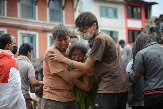 Un rescatista consuela a sobrevivientes del terremoto en Nepal.