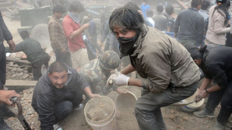 Personas remueven escombros en Katmandú.
