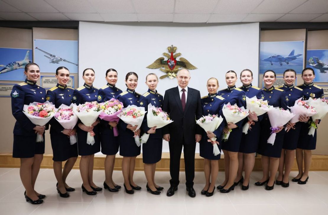 En esta fotografía distribuida por la agencia estatal rusa, el presidente ruso Vladimir Putin (C) posa con las graduadas de la Escuela Superior de Pilotos de Aviación Militar de Krasnodar en Krasnodar el 7 de marzo de 2024.