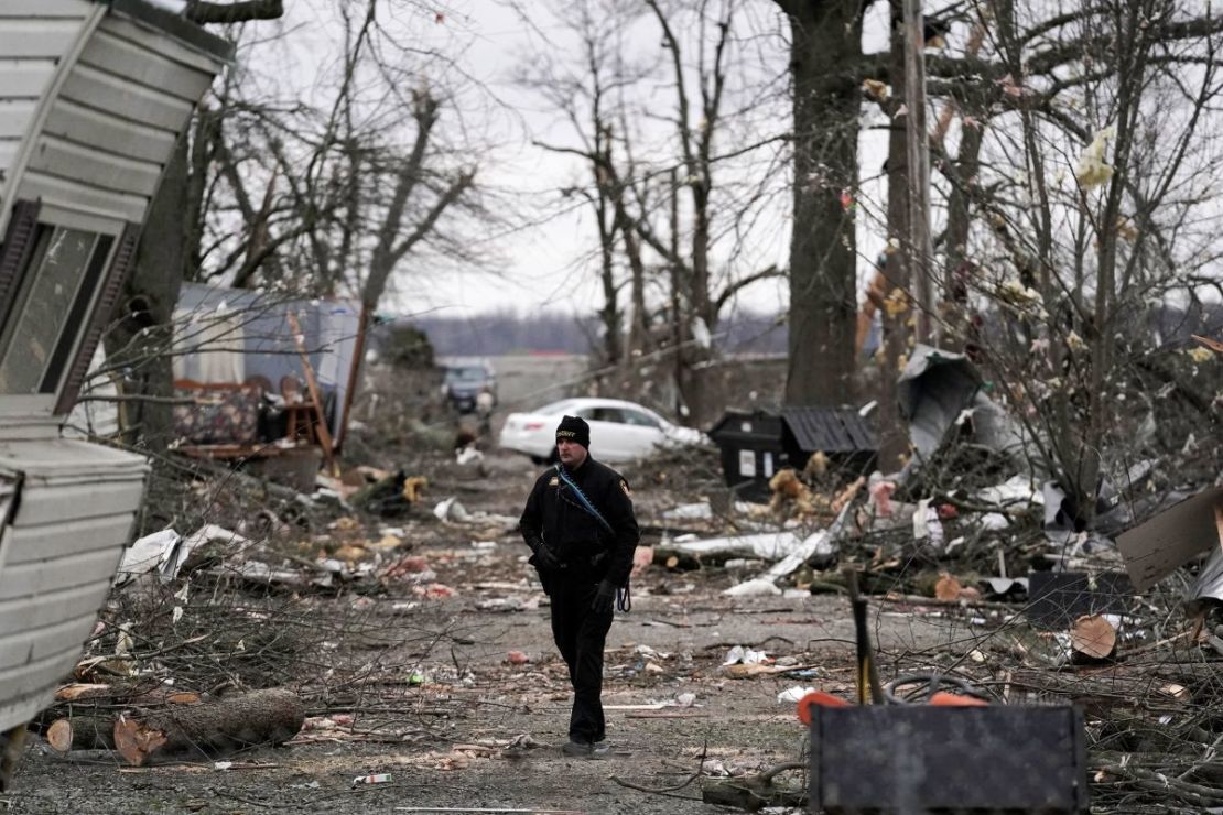 Un sheriff del condado de Logan camina por una carretera el viernes después de la fuerte tormenta del jueves, en Lakeview, Ohio