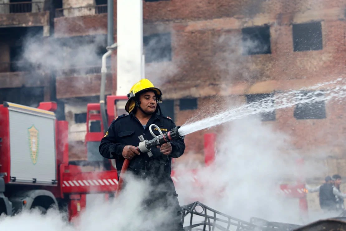 Un bombero enfría la zona mientras continúa ardiendo.