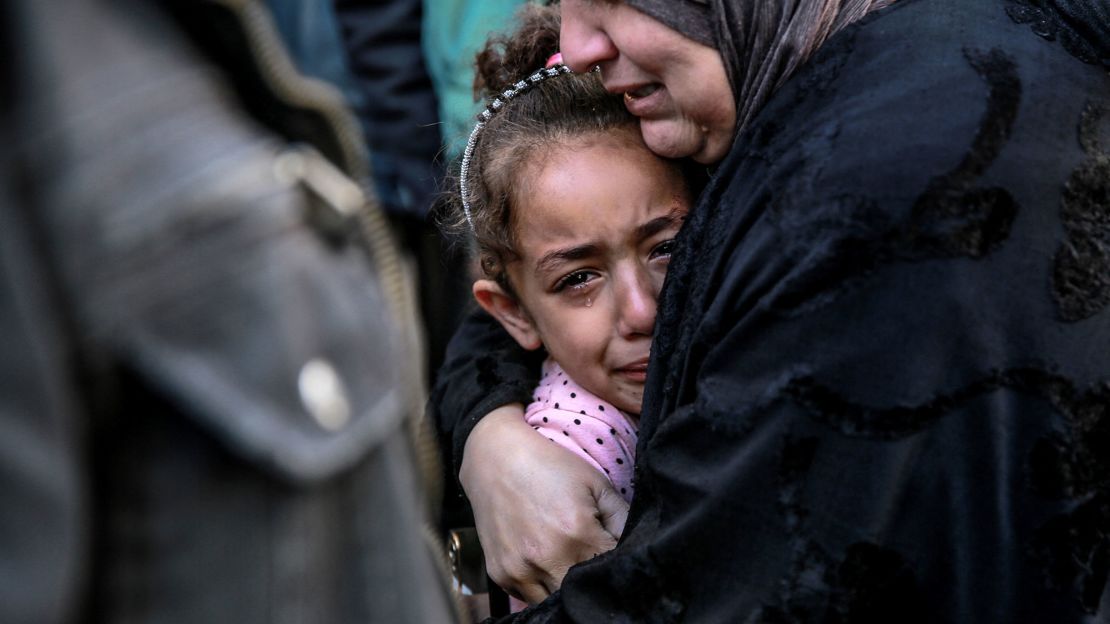 Una mujer palestina sostiene a una niña mientras lloran a sus familiares muertos en un bombardeo israelí frente a la morgue del hospital Al-Shifa en la ciudad de Gaza el 15 de marzo de 2024.