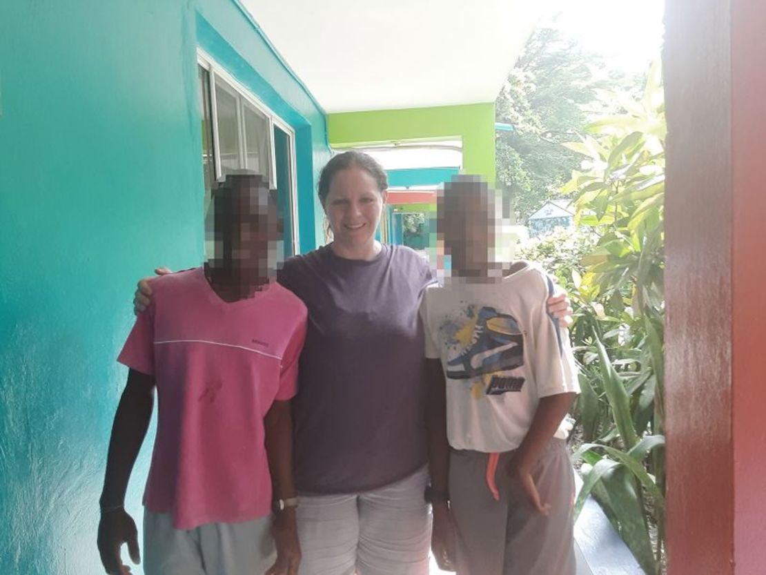 Missy Tennant se ve en una foto sin fecha con los dos niños de Haití que ahora están atrapados en un orfanato allí. CNN borró los rostros de los niños para proteger su identidad.