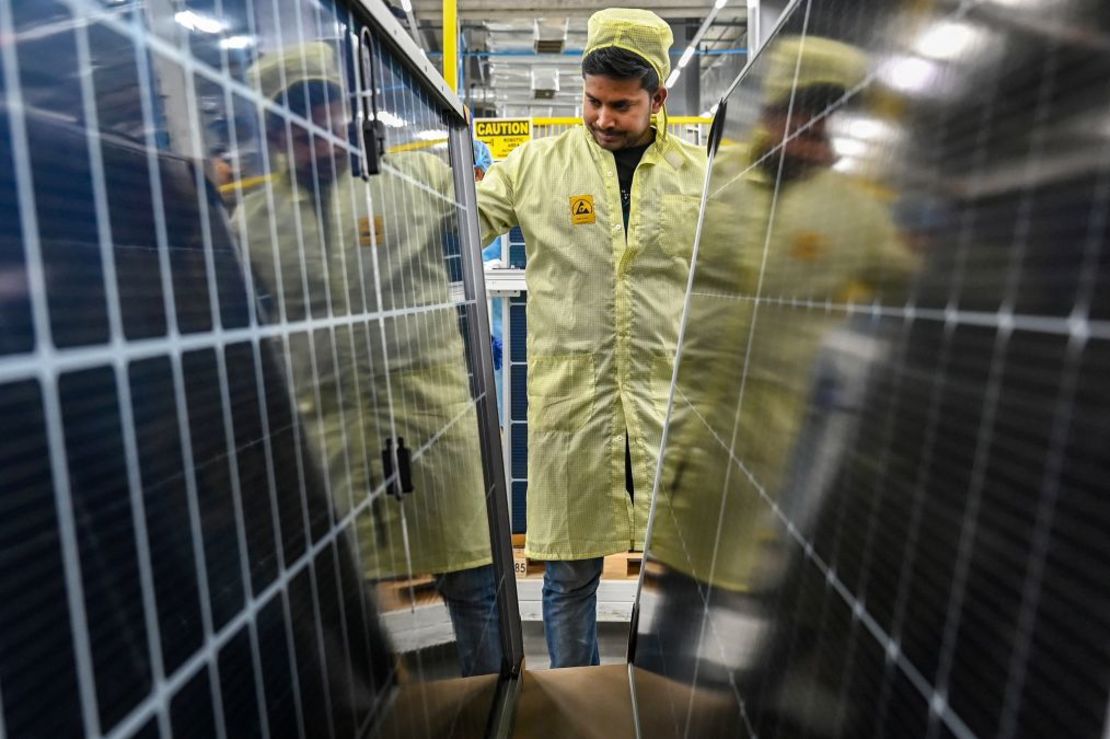 Un empleado inspecciona paneles solares en una fábrica del Grupo Adani en Mundra. Crédito: Punit Paranjpe/AFP/Getty Images