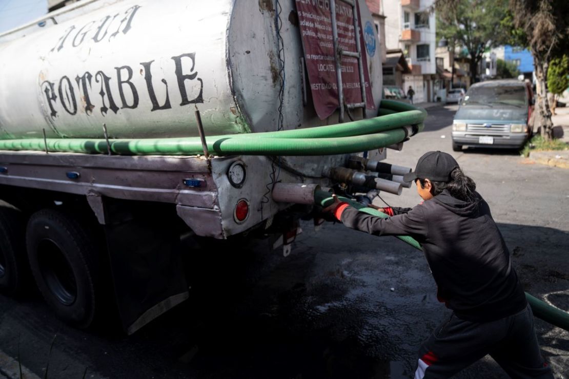 Un trabajador conecta una manguera a un camión cisterna afuera de un complejo de departamentos en el barrio Las Peñas en Iztapalapa el 27 de febrero de 2024 en Ciudad de México, México.