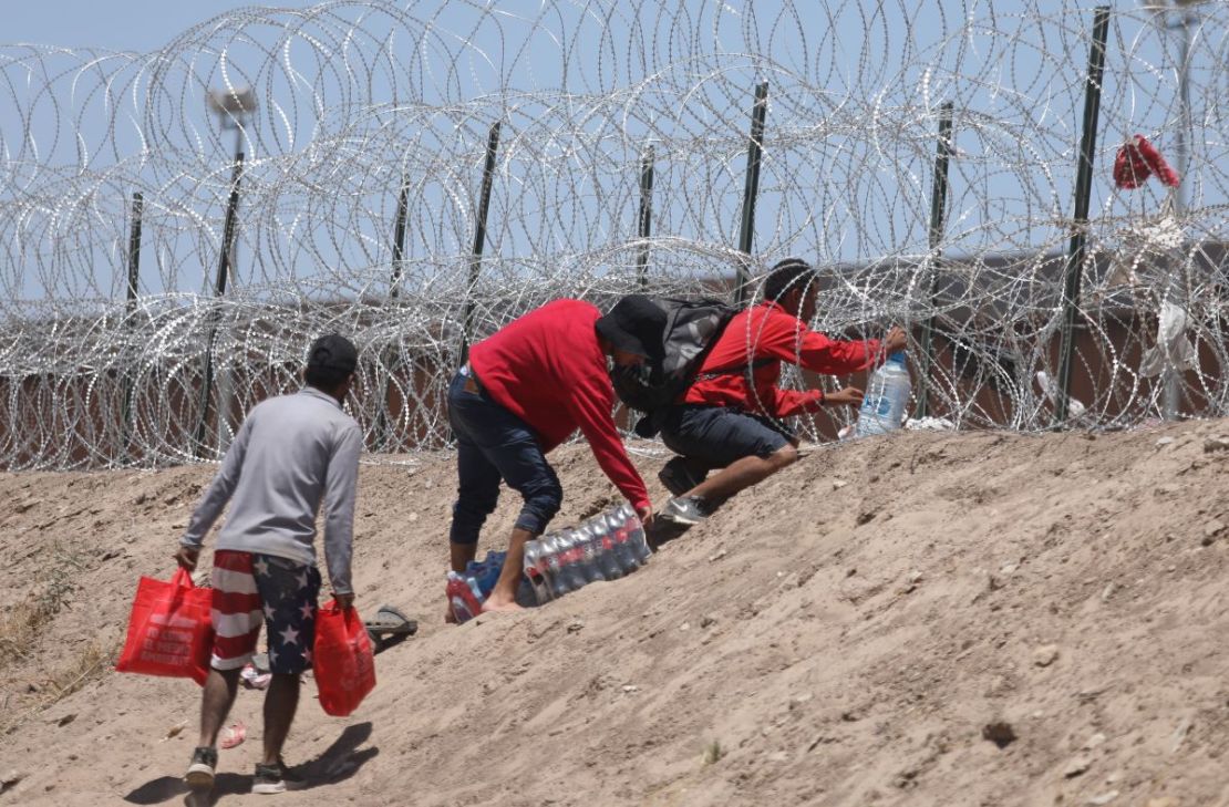 Los migrantes cruzan a orillas del Río Grande mientras esperan ser procesados ​​por la Patrulla Fronteriza del Sector El Paso, Texas.