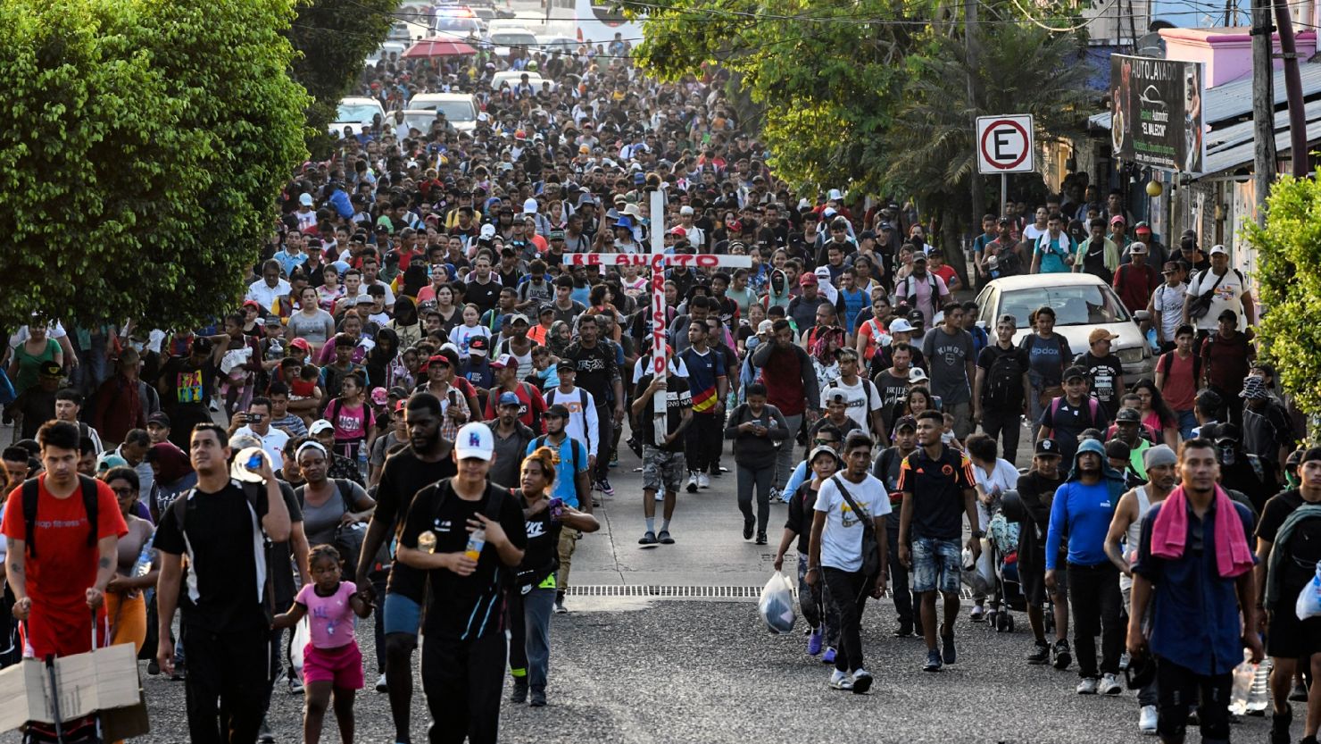 Migrantes llevan una cruz al frente de una caravana que pretende llegar a la frontera entre México y Estados Unidos, saliendo desde Tapachula, estado de Chiapas, el 25 de marzo de 2024.
