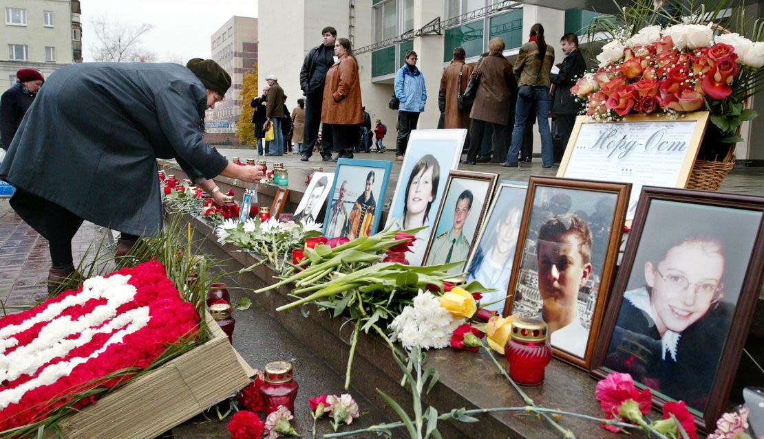 Una mujer coloca un retrato de su familiar frente al Teatro Dubrovka de Moscú, el 26 de octubre de 2004, donde comandos chechenos tomaron cientos de rehenes. La mayoría de las 130 víctimas civiles del asedio murieron a consecuencia de un gas letal que las fuerzas especiales rusas utilizaron al asaltar el teatro. Crédito: Denis Sinyakov/AFP/Getty Images